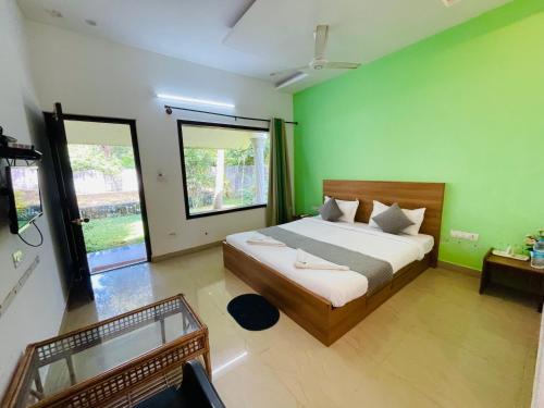 a bedroom with a large bed with green walls at Sea Mist Beach Villas Alleppey in Alleppey