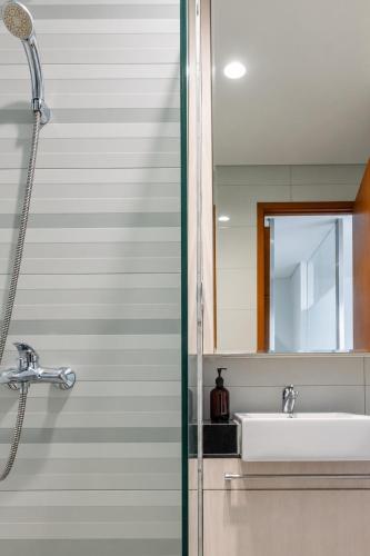 a bathroom with a sink and a mirror at Dago Suite 3BR Luxury Apartment in Bandung