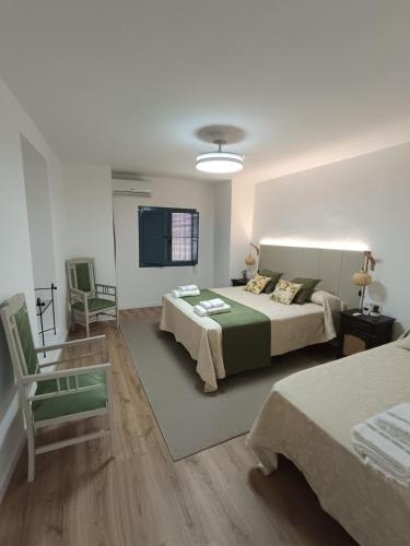 a bedroom with two beds and a chair in it at Casa Ameghino in Laujar de Andarax