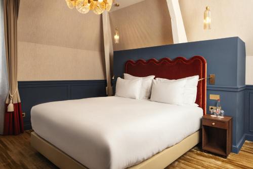a bedroom with a large white bed with a blue headboard at Château du Portereau in Vertou