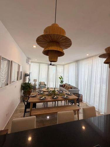 a living room with a wooden table and a large chandelier at Bajareque Oceanfront Luxury 3 BR Villa in Telchac Puerto