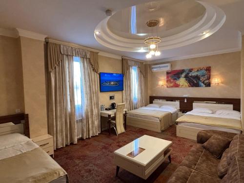 a hotel room with two beds and a couch at Agava Tbilisi in Tbilisi City