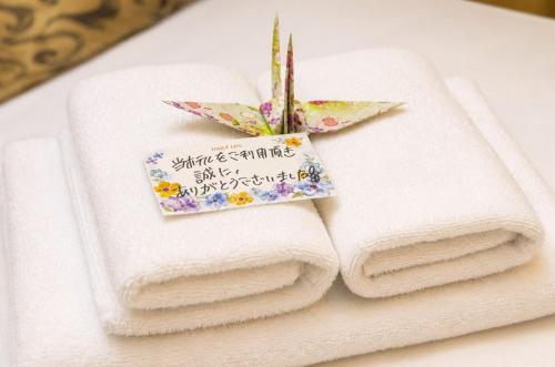 a pile of towels sitting on a table with a note at MrKINJO in Air Resort in Hirara