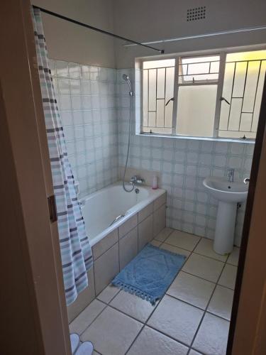 a bathroom with a tub and a sink at Oolele BnB Newcastle in Newcastle