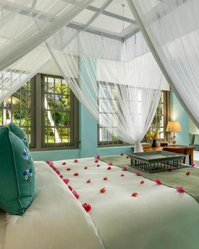 a bedroom with a large bed with roses on it at udesh hotel in Minuwangoda