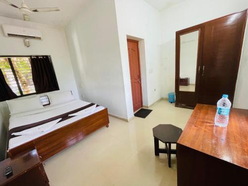 a bedroom with a bed and a table and a chair at Sea Mist Beach Villas Alleppey in Alleppey