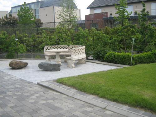 two stone benches sitting in a park with a grass at Hotel Oude Eycke in Maaseik