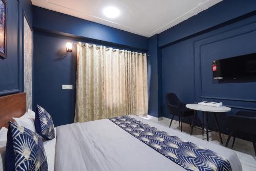 a blue room with a bed and a table at FabHotels Norvia in New Delhi
