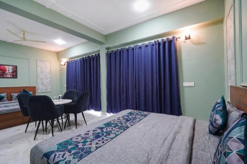 a bedroom with a bed and a table with chairs at FabHotels Norvia in New Delhi