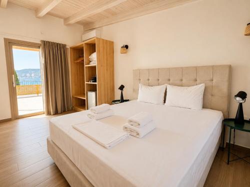 a bedroom with a large white bed with towels on it at Dolphin hotel in Korfos