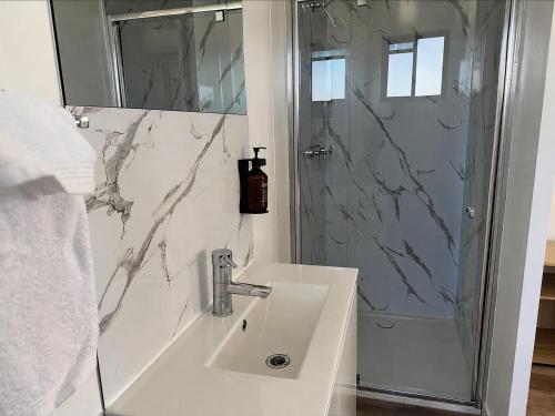 a white bathroom with a sink and a shower at Crows Nest Tourist Park in Crows Nest