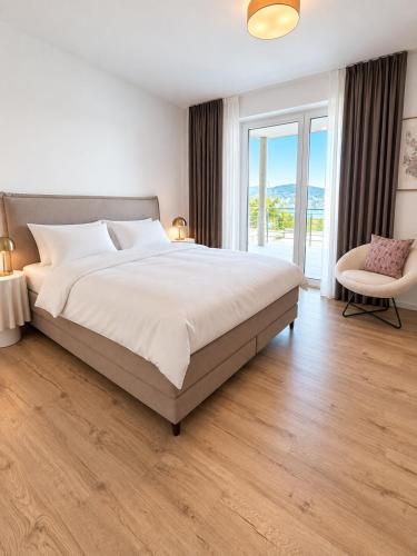 a bedroom with a large bed and a chair at Maria Blick in Maria Wörth