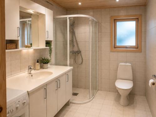 a bathroom with a shower and a sink and a toilet at Rønsholmen brygger in Beian