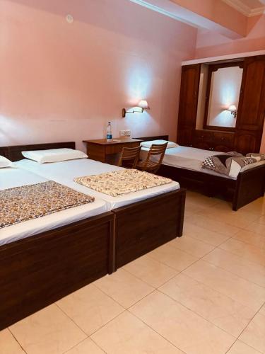 a room with two beds and a mirror at Tvm stays in Trivandrum