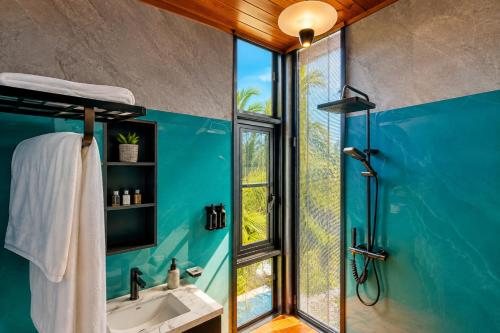 a bathroom with a shower and a sink and a window at TUNA Hiriketiya - Luxury Resort & Pool Retreat in Hiriketiya