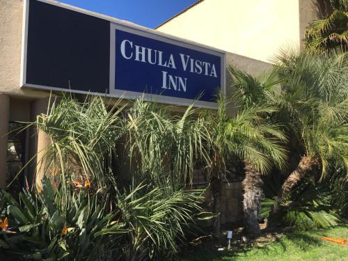 a sign in front of a building with palm trees at Chula Vista Inn in Chula Vista