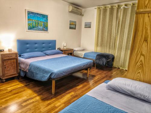 a bedroom with two beds and a blue headboard at Bed and Breakfast La Contessa in Santo Stefano