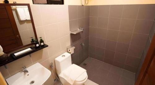 a bathroom with a toilet and a sink and a mirror at Keep Diving Resort Bohol in Taporok