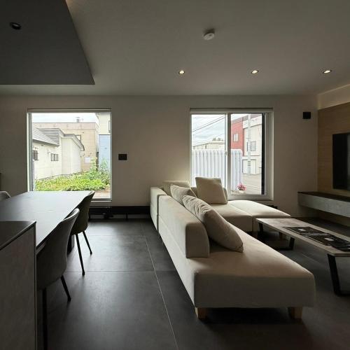 a living room with a couch and a table and two windows at S suzukou in Asahikawa