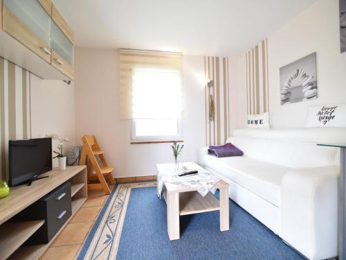 a living room with a white couch and a table at Boutique Bungalow in Insel Poel with terrace in Insel Poel