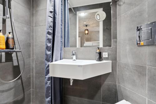 a bathroom with a white sink and a shower at Fyrtojet in Odense