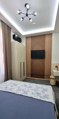 a bedroom with a bed and a wooden wall at Maftun Guest House in Samarkand