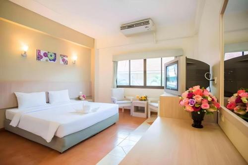 a bedroom with a large white bed and a television at Bunjongburi Hotel in Ban Tha Kup