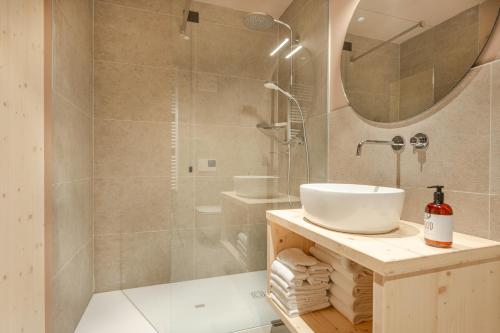a bathroom with a sink and a shower with a mirror at Agriturismo Maso Loera in Pelugo