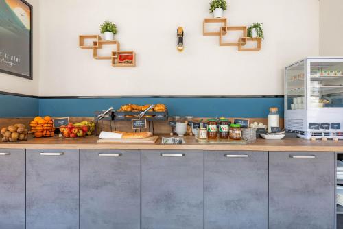 a kitchen with a counter with fruits and vegetables at Appart'City Classic Clermont Ferrand Centre in Clermont-Ferrand