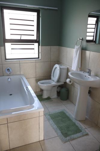 a bathroom with a tub and a toilet and a sink at Nao's Place in Dorchester Heights 