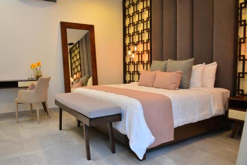 a bedroom with a large bed and a mirror at Elements Tulum Boutique Hotel in Tulum