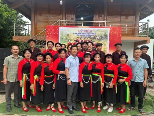 a group of people posing for a picture in front of a banner at Trà My Homestay in Nhữ Khê