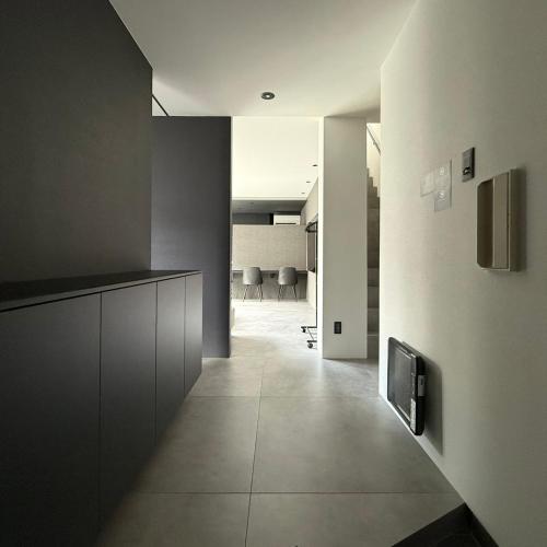 a hallway of a room with a kitchen and chairs at U suzukou in Asahikawa
