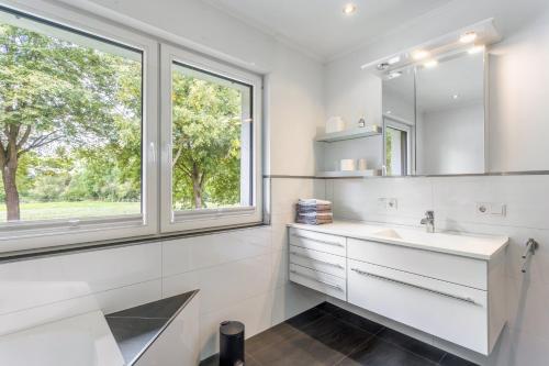 a white bathroom with a sink and a window at Fewo Wrede am Sauerland-Radring 1 in Wenholthausen