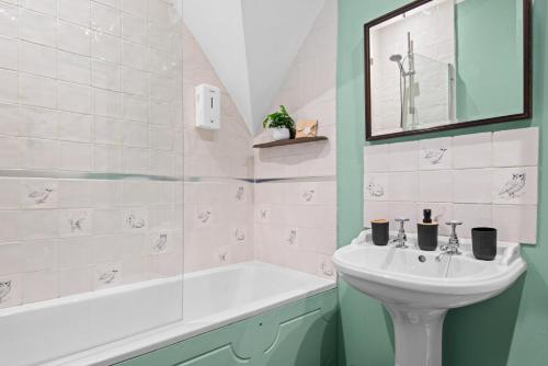 a bathroom with a sink and a bath tub and a sink at Traditional Cotswold escape with garden and fireplace in Cheltenham