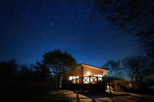 a house lit up at night under a starry sky at Suite Villa Panora Yatsugatake in Minamimaki