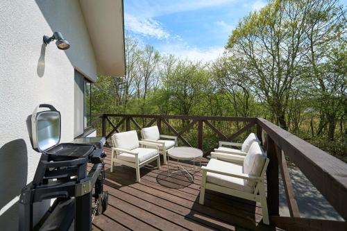 a patio with chairs and a grill on a deck at Suite Villa Panora Yatsugatake in Minamimaki