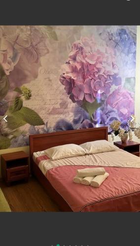 a bedroom with a painting of flowers on the wall at Готель Аркан in Kolomiya