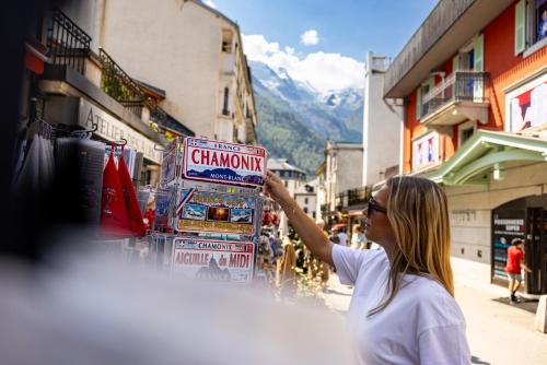a woman is holding up a sign on a street at Hôtel de L'Arve by HappyCulture in Chamonix