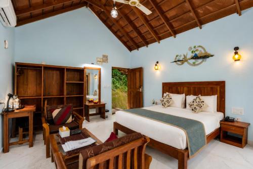 a bedroom with a bed and a desk and a chair at Hill Crest Resort - Coorg in Madikeri
