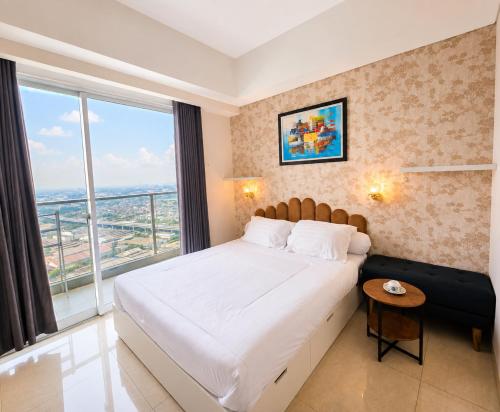 a bedroom with a large bed and a large window at Modern studio with a stûnning view at 32 floor in Jakarta