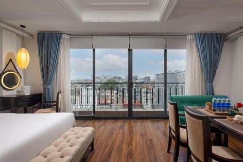 a bedroom with a bed and a table with a dining room at Golden Legend Boutique Hotel in Hanoi
