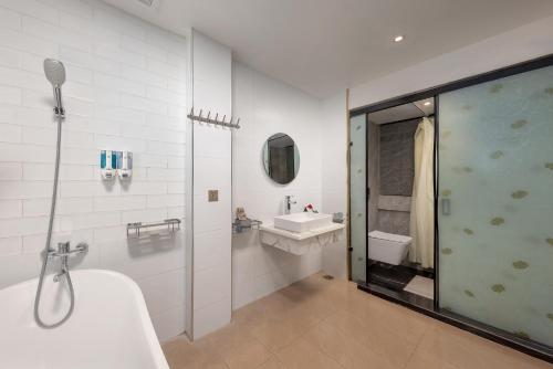a bathroom with a shower and a sink and a tub at Golden Legend Boutique Hotel in Hanoi
