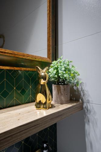a statue of a rabbit sitting on a shelf next to a plant at Penzión Aira in Zvolen