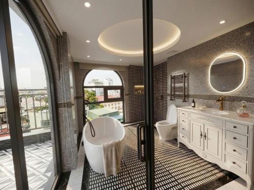 a bathroom with a tub and two sinks and a window at GRAND SOL LUXURY BOUTIQUE Hotel in Hanoi