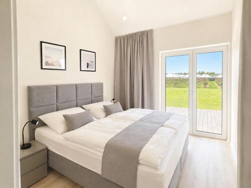 a bedroom with a large bed and a large window at Ferienhaus Elbdeichblick 2 in Haselau