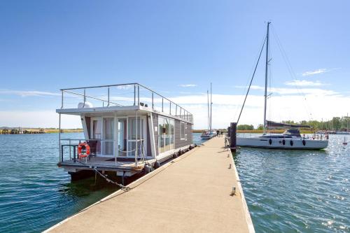 a boat is docked at a dock on the water at Hausboot Lydia in Gager in Gager