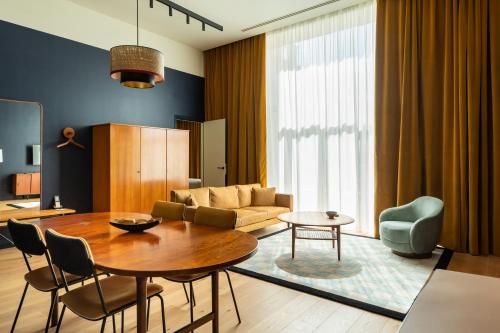 a living room with a table and a couch at Faubourg 21 - The Leading Hotels of the World in Brussels