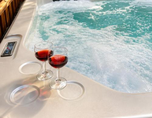 two glasses of wine sitting on a bath tub at BeLev Odem in Odem