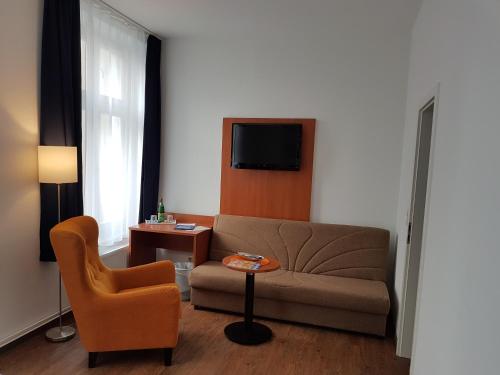 a living room with a couch and a chair at Hotel Amber Altstadt in Stralsund